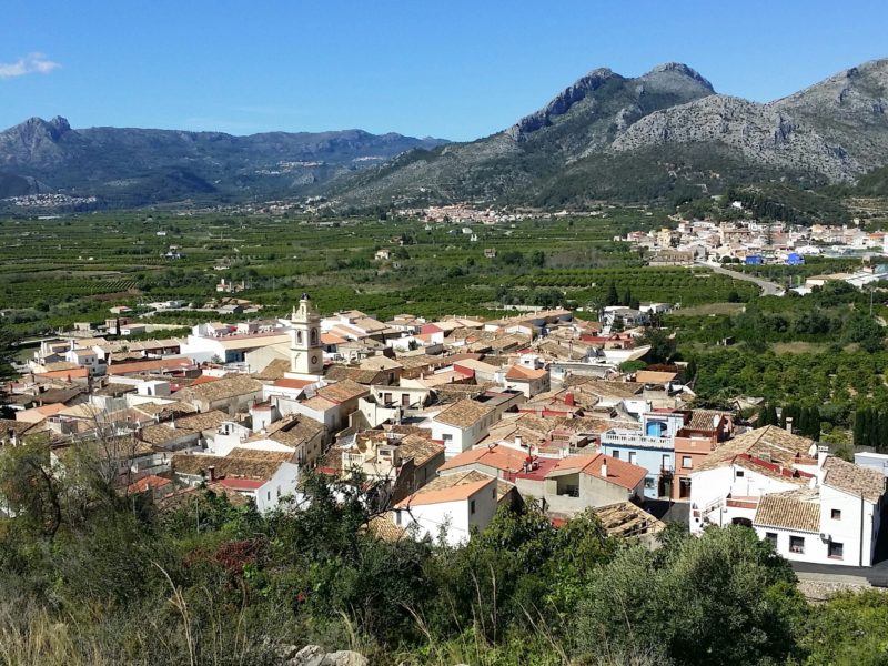 Hills, fields, village of low houses, blue sky.