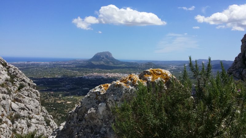 Rocks at peak of mountain, distant hills, blue skies.