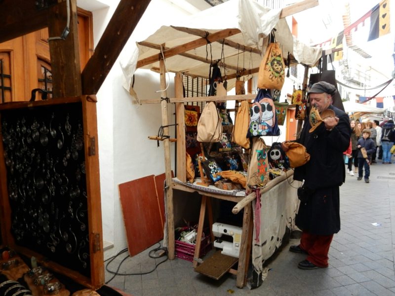 Street market, wooden stalls, leather goods, sewing machine.