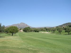 Golf course, trees, Montgo mountain, blue skies.